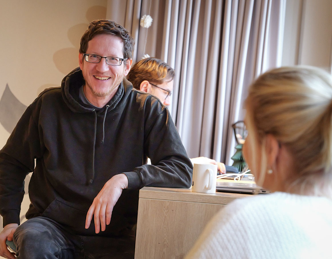 Zwei Männer arbeiten fröhlich zusammen und haben eine Mindmap auf einem Whiteboard abgebildet